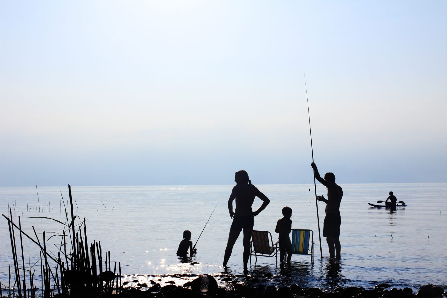 family fishing together around sunset